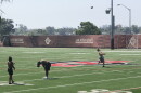 Three SDSU football players practice on a campus football field, Sept. 25, 2020.