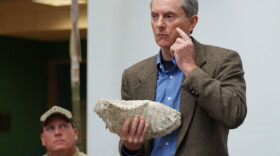 Dr. Thomas Deméré, Curator of Paleontology at the San Diego Natural History Museum, presents a fossil of a mammoth molar found in the East Village. Behind him sits the lead field paleontologist on the project, Pat Sena. The Natural History Museum presented the fossils, including a mammoth and a gray whale, on February 17, 2010.