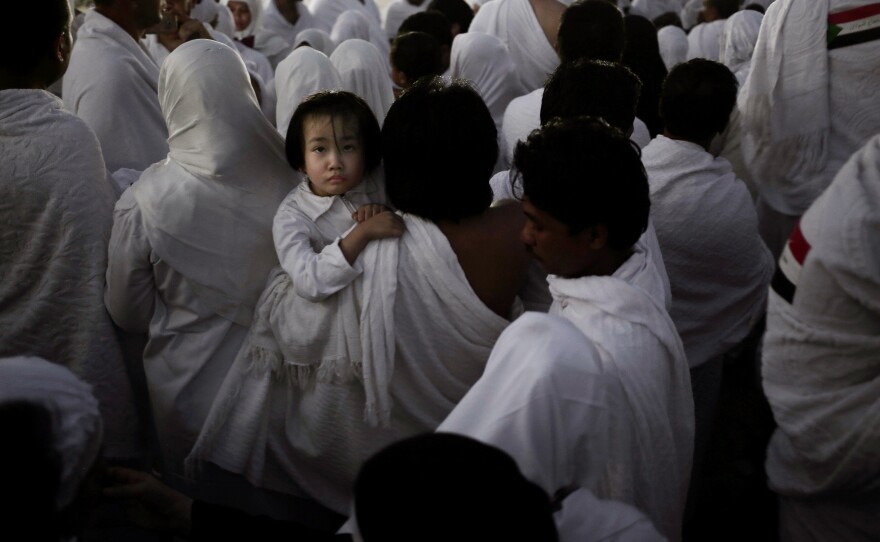 An Indonesian father carries his daughter through the crowd after reaching the top of a rocky hill known as Mount Arafat.