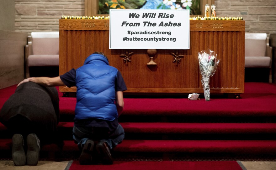 Mourners pray for the victims of the Camp Fire during a vigil Sunday in Chico, Calif. The wildfire killed dozens of people and effectively wiped the entire town of Paradise off the map.