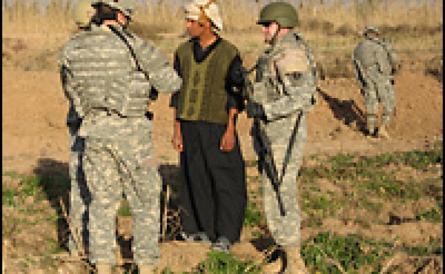 U.S. soldiers on patrol question an Iraqi farmer.