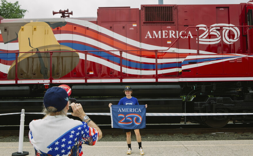 Adam Lapham, 25, of Green, Ohio, stands for a photograph taken by his grandfather, James Wallace, 74,  in front of a train car connected to Union Pacific's Big Boy No. 4014, the world's largest operating steam engine locomotive, during a stop in Philadelphia.