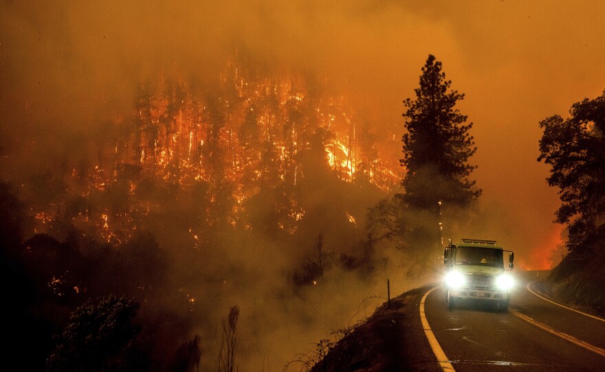 A firetruck drives along California Highway 96 as the McKinney Fire burns on Saturday.
