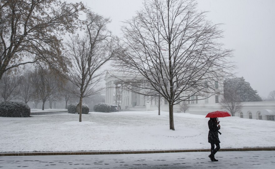 Snow falls outside the White House during a spring storm on Wednesday in Washington, D.C. The nor'easter impacted much of the East Coast, canceling flights, schools and work for many residents.