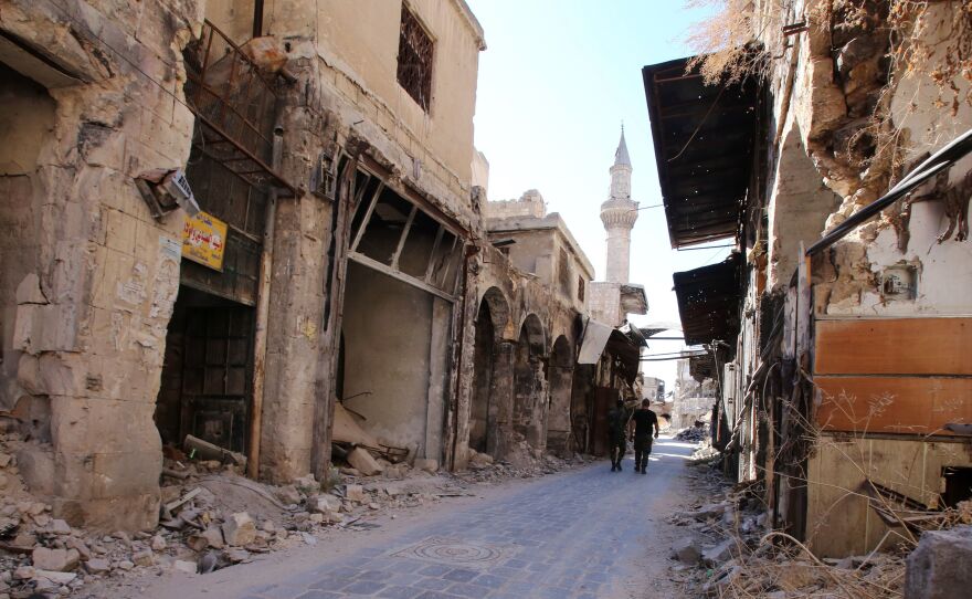 Syrian government soldiers walk in the damaged government-held side of Aleppo on Sept. 16. Initially, U.N. officials had observed calm in war-ravaged Aleppo during the recent cease-fire, but Saturday's violence in the country's eastern regions spells ill news for the truce.