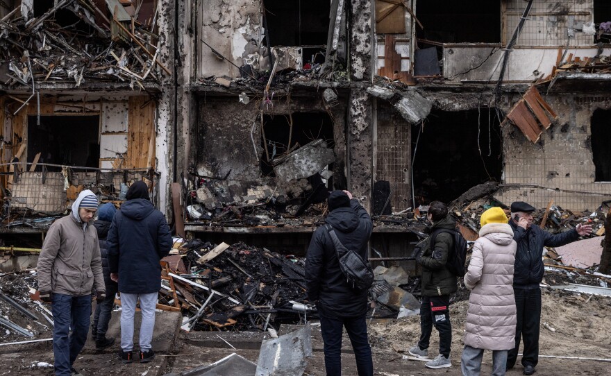 People look at the exterior of a damaged residential block hit by an early morning missile strike on Feb. 25, 2022 in Kyiv, Ukraine.