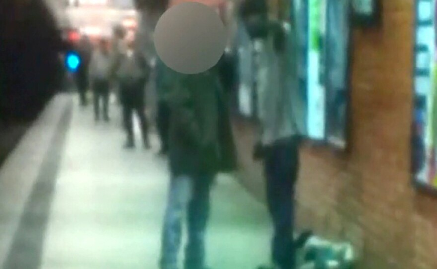 Before the attack: Two men are seen talking on a New York City subway platform Monday in this framegrab from a video released by the New York City Police Department. Moments later, police say, Ki-Suk Han (whose face is obscured) was pushed on to the tracks.