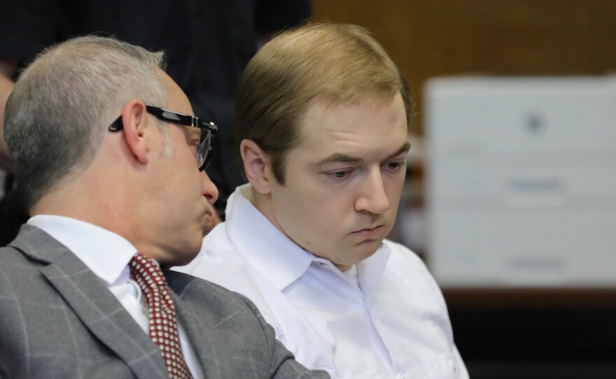 James Jackson (right) confers with his lawyer during a hearing in criminal court Wednesday in New York. Jackson pleaded guilty to killing a black man with a sword, which prosecutors described as terrorism and a hate crime.