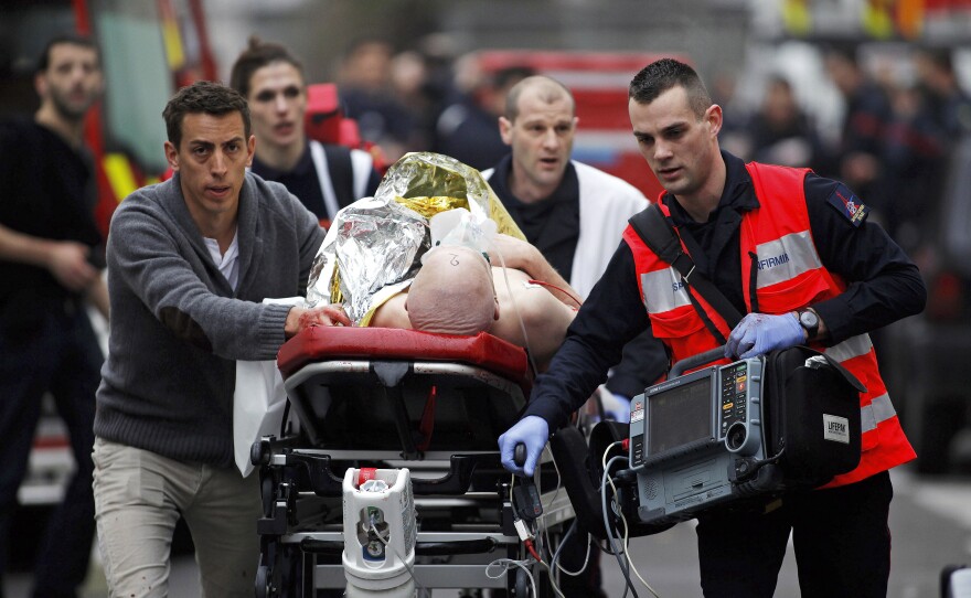 An injured person is evacuated outside the office. In 2011, Charlie Hebdo was the target of a firebomb attack after it printed a drawing of the Prophet Muhammad.