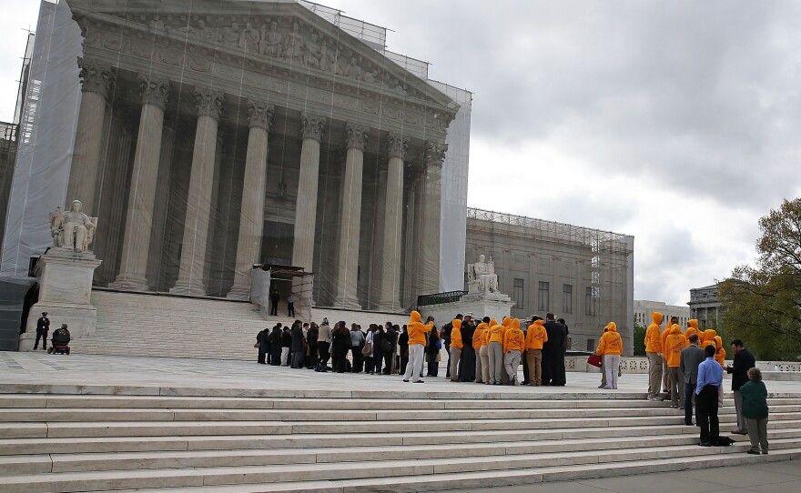People line up to enter the Supreme Court on Monday for arguments.