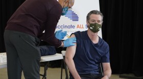 Dr. Mark Ghaly, Secretary, California Health and Human Services, left, inoculates California Gov. Gavin Newsom, right, at the Baldwin Hills Crenshaw Plaza in Los Angeles Thursday, April 1, 2021. Newsom was vaccinated with the new one-dose Janssen COVID-19 vaccine by Johnson & Johnson. 