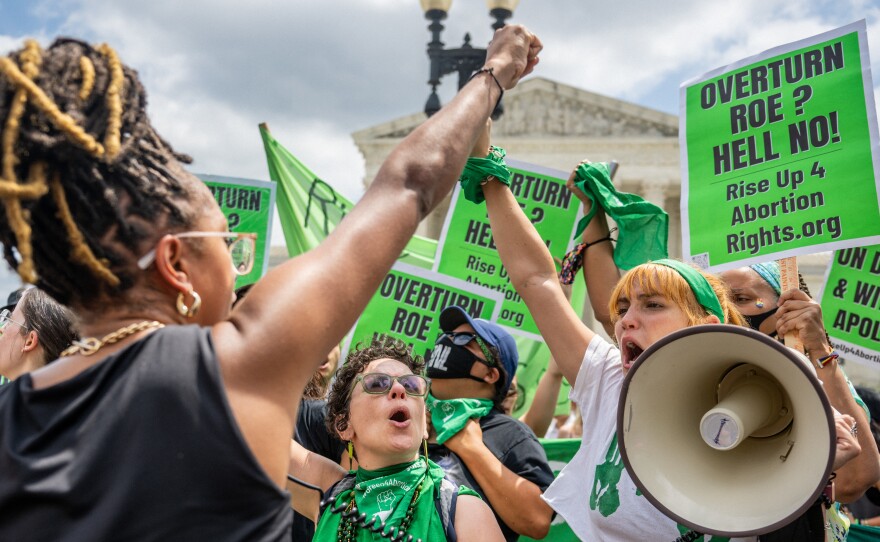 Abortion rights activists clad in green and carrying green signs protest outside the Supreme Court on Saturday.