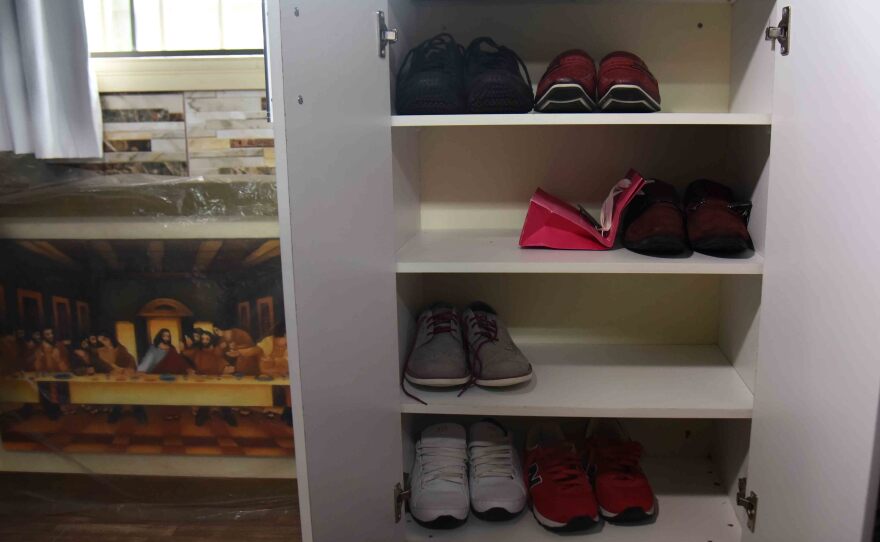 Shoes, art and a tiled wall in Chimenes Pavao's prison quarters.