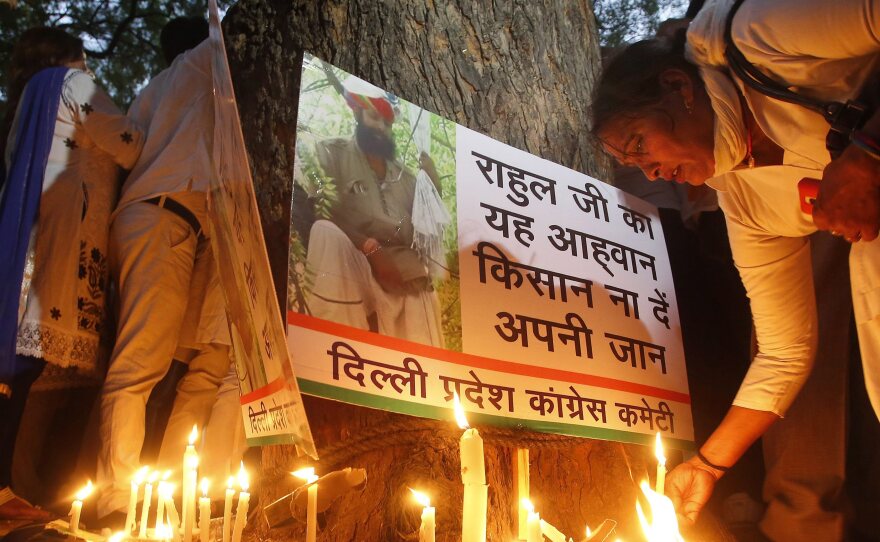 An Indian National Congress party worker on Thursday pays tribute to Gajendra Singh, a farmer who committed suicide during a candlelight vigil in New Delhi the previous day.