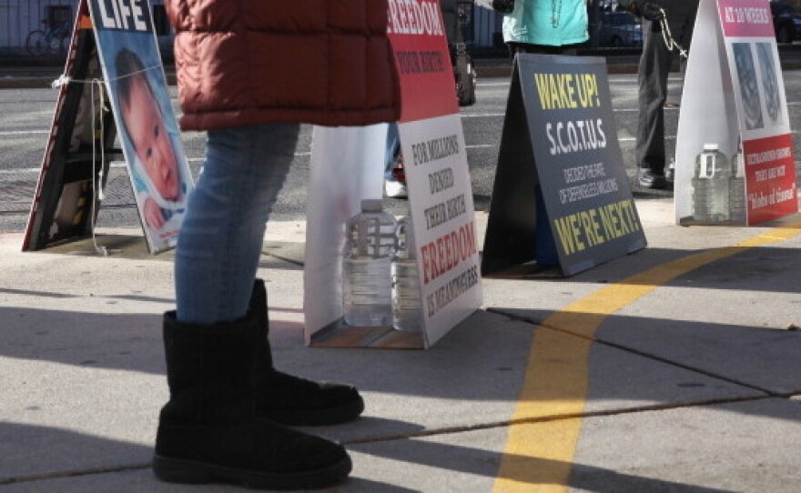 Anti-abortion protesters assemble outside the Planned Parenthood clinic in Boston on Dec. 7. The protesters are legally behind the 35-foot buffer zone, which is marked by a painted yellow line on the sidewalk.