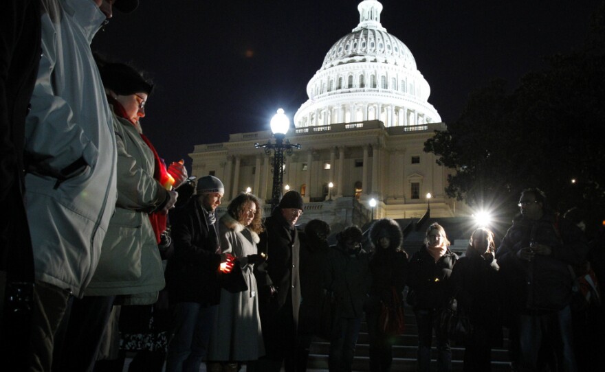 People gather for a candlelight vigil for the victims of the shooting rampage, at the steps of the Capitol in Washington on Saturday.