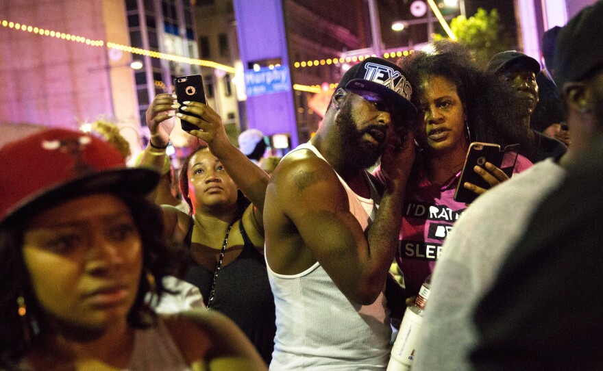 Protesters react as police officers arrest a bystander in downtown Dallas following Thursday's shooting.