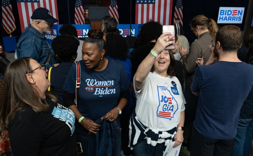 Paula Benson, in white, attended a rally for President Joe Biden in Atlanta and hopes voters aren't complacent in November.