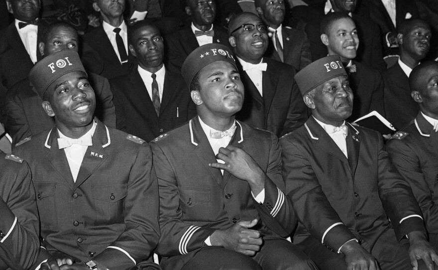 Ali listens intently to Elijah Muhammad, leader of the Nation of Islam, as Muhammad gives a marathon speech to black Muslims in Chicago on Feb. 28, 1966. The fighter had dropped the name Cassius Clay in 1964 and adopted the Muslim name Muhammad Ali.