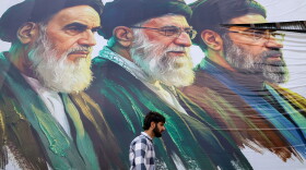 A man walks past a billboard featuring the portraits of (right to left) Iran's new Supreme Leader Ayatollah Mojtaba Khamenei, the late Supreme Leader Ayatollah Ali Khamenei, and the late Supreme Leader Ayatollah Ruhollah Khomeini, in Srinagar, Jammu and Kashmir, on June 15.