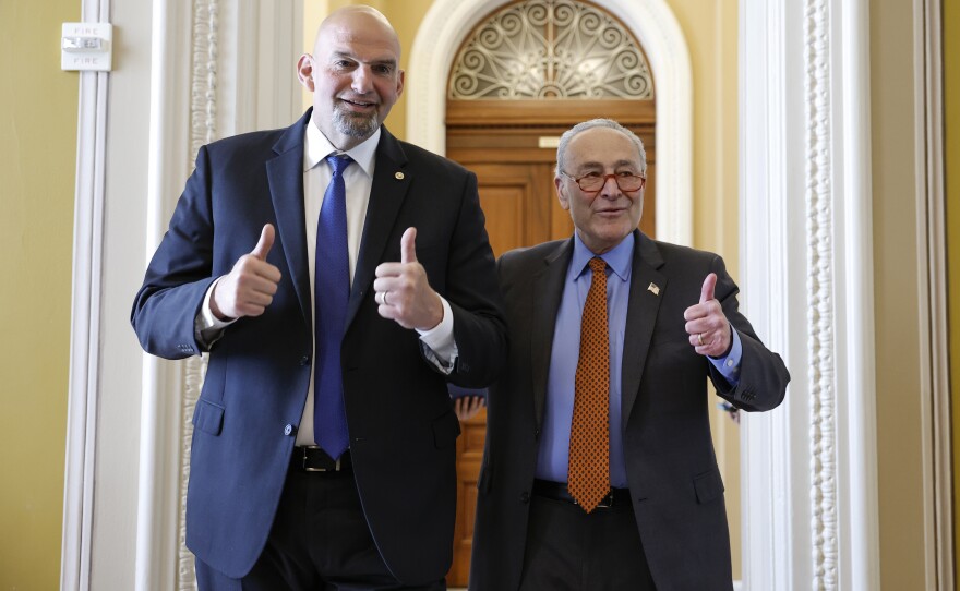 Sen. John Fetterman and Senate Majority Leader Chuck Schumer give a thumbs up to reporters as they walk to the weekly Senate policy luncheons together at the U.S. Capitol Building on April 18.