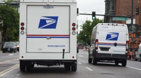 A USPS logo adorns the back doors of United States Postal Service delivery vehicles as they proceed westbound along 20th Street from Stout Street and the main post office in downtown Denver, Wednesday, June 1, 2022.