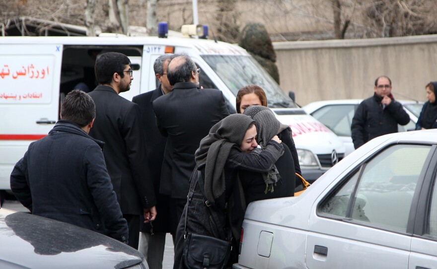 Relatives of passengers on board a plane that crashed into a mountain Sunday, mourn at Mehrabad International Airport in Tehran on Sunday. All 65 people aboard were feared dead.