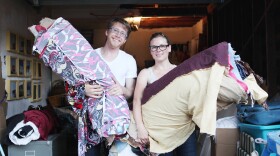 Alexander and Savannah Jarman stand at the opening to their Hillcrest studio and hold sections of their picnic blanket.