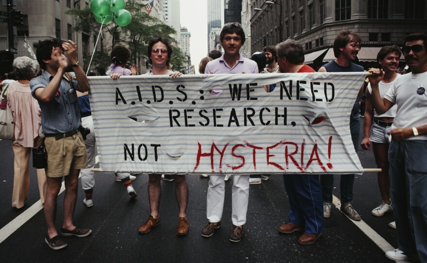 Gay Pride marchers parade through Manhattan carrying a banner that reads, "A.I.D.S.: We need research, not hysteria!" in June 1983.