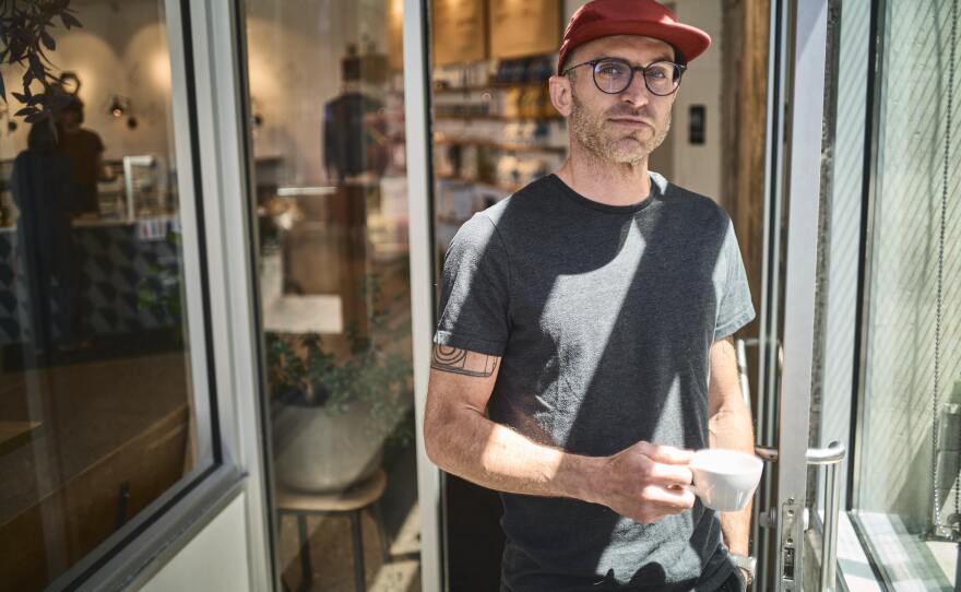 Scott Lucey stands in the entryway of Likewise in Milwaukee. Before opening the café in 2015, Lucey worked for 12 years as a barista and trainer for Alterra Coffee but always dreamed of having his own business.