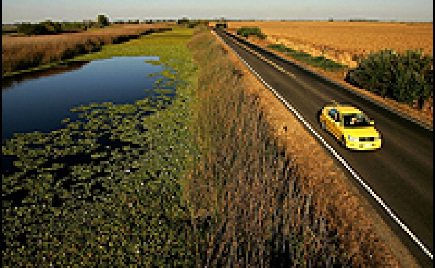 Water is held back from a lower-elevation farm by a section of Highway 4 that serves as a levee road in the Sacramento-San Joaquin River Delta in California.