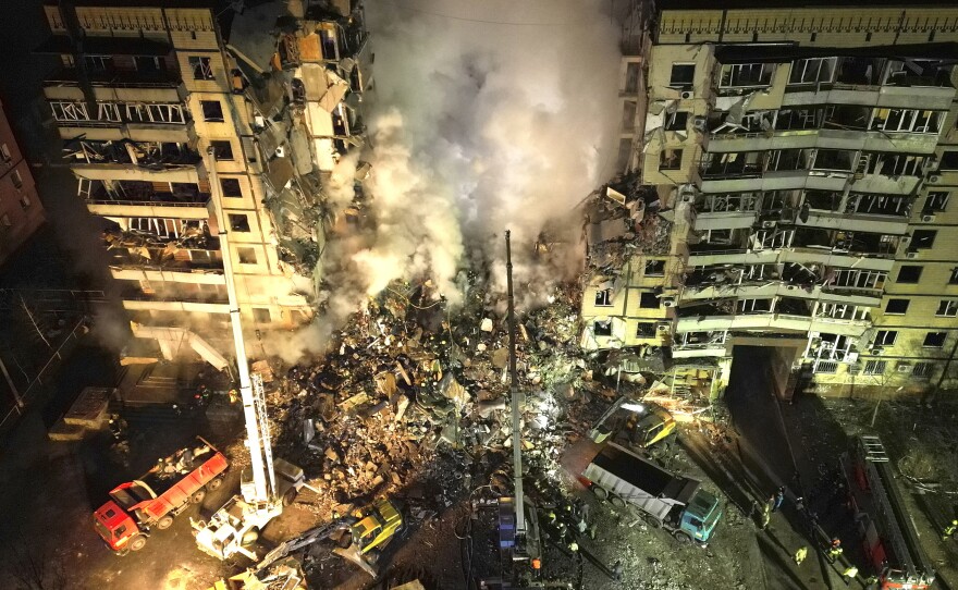 Emergency workers clear the rubble after a Russian rocket hit a multistory building leaving many people under debris in the southeastern city of Dnipro, Ukraine, on Jan. 14, 2023.