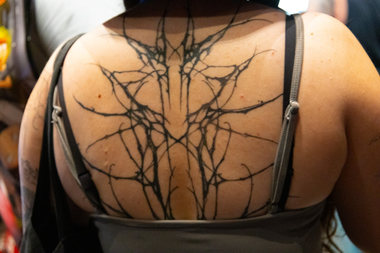 A cybersigilism-style back tattoo spans a Comic-Con attendee's back, July 24, 2026.