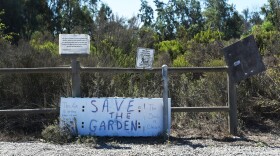 A handwritten sign in front of the Tijuana River Community Garden reads, "Save the Garden," on Oct. 1, 2025.