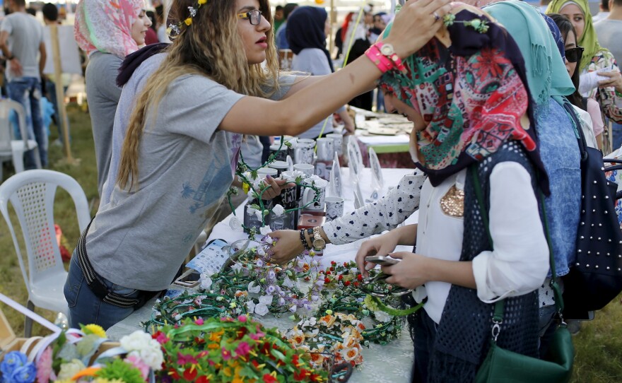 Women make flower garlands at the carnival. This year's theme is diversity, to encourage Iraqis to overcome sectarianism.