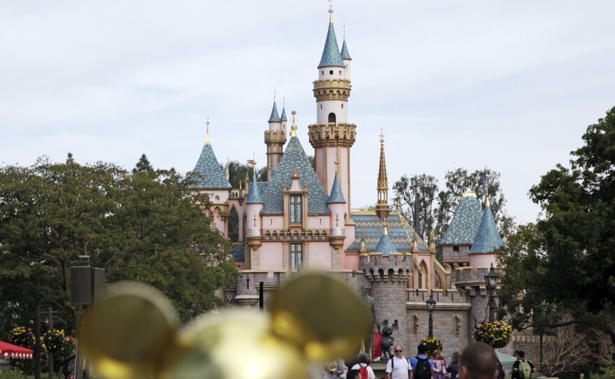 Visitors walk toward Sleeping Beauty's Castle at Disneyland in Anaheim, Calif.