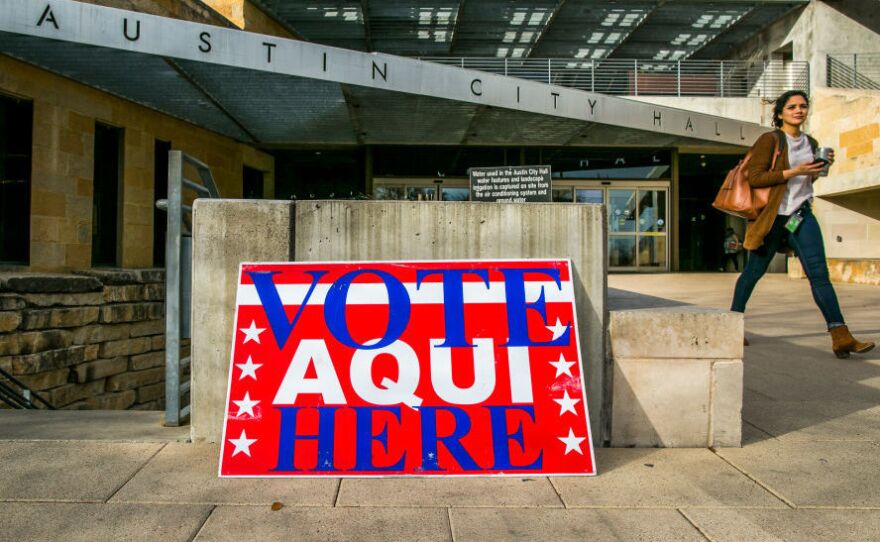 A pedestrian walks past Austin City Hall, an early voting center, on Tuesday in Austin, Texas.