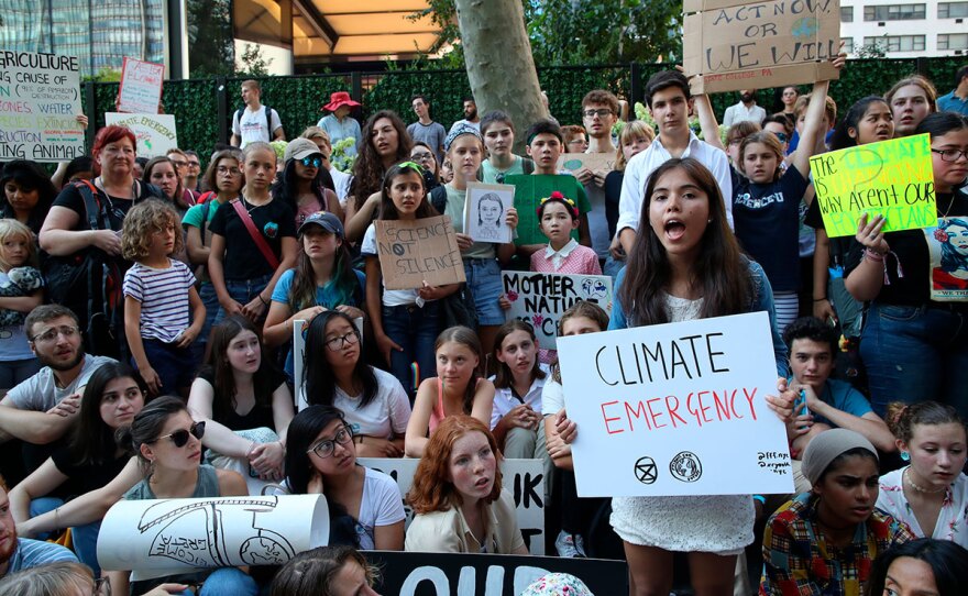 Swedish environmental activist Greta Thunberg, center in orange shirt, participates in a Youth Climate Strike outside the United Nations, Friday, Aug. 30, 2019 in New York. 