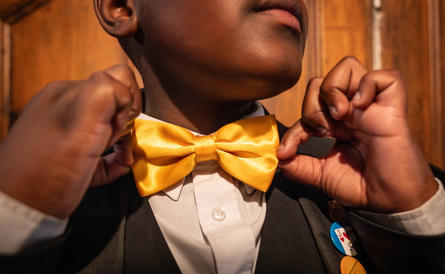Prestidigitation pupil Lubelo Mthenjana adjusts his bow tie. Many of the College's students sport traditional magician attire like bow ties and top hats.