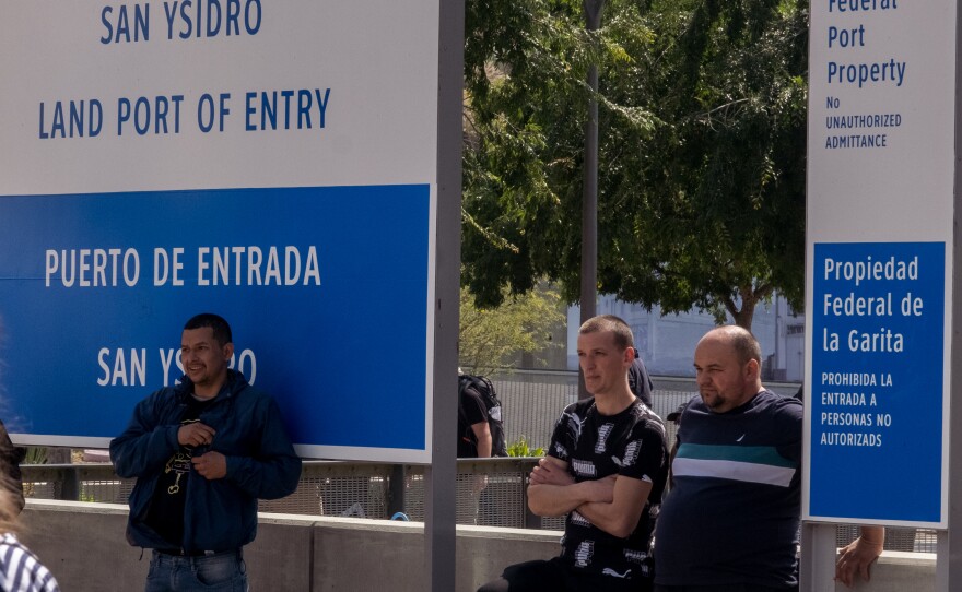 Ukrainian war refugees wait in San Diego near the Port of Entry for a ride to the Calvary San Diego church in Chula Vista just after being allowed to claim asylum in the United States, April 1, 2022.