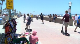 Scooters and bikes riders on the Mission Beach Boardwalk, July 1, 2019. 