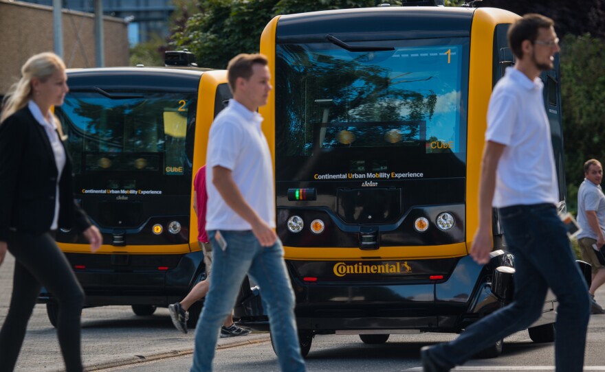 New research explores how people think autonomous vehicles should handle moral dilemmas. Here, people walk in front of an autonomous taxi being demonstrated in Frankfurt, Germany, last year.
