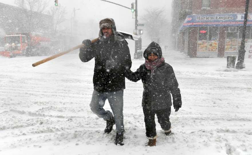 Pedestrians cross the street in Harlem during a snow storm on Thursday in New York City. As a major winter storm moves up the Northeast corridor, New York City is under a winter storm warning.