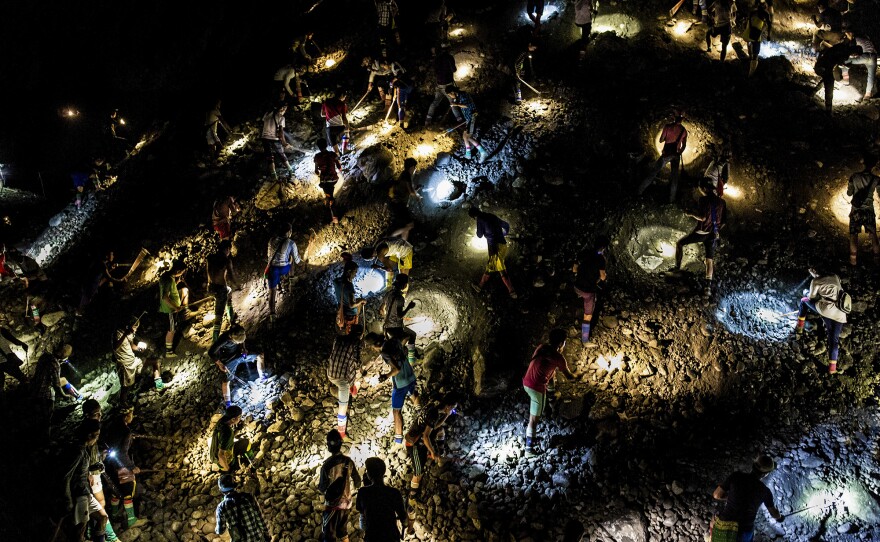 Freelance miners use flashlights to search for jade at night, during company off-hours, in Hpakant in 2019.