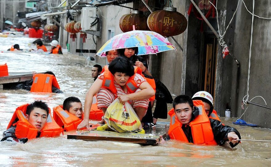 Rescue workers lead people through floodwaters brought by the typhoon in Ningde in Fujian province on Wednesday.