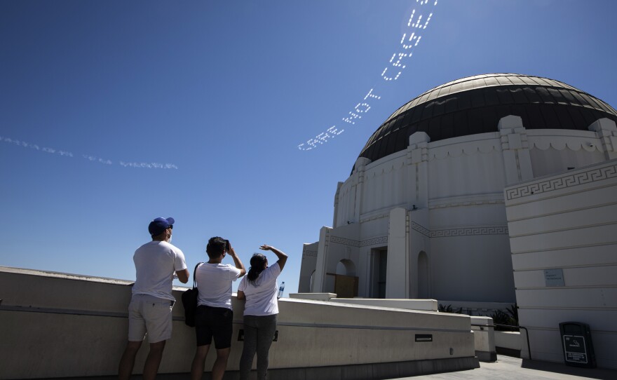 The words "Care, not cages" are viewed from the Griffith Observatory in L.A. The activist Patrisse Cullors had them flown over the city's Men's Central Jail. "What we are challenging the county to do right now is to actually invest into our communities through an alternatives to incarceration fund," says Cullors.