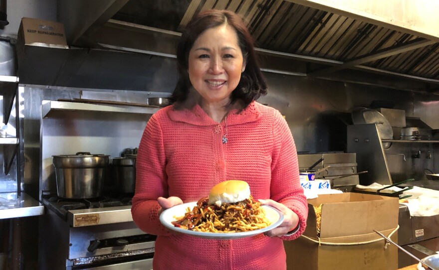 Regina Mark, co-owner of Mee Sum Restaurant in Fall River, Mass., holds a chow mein sandwich, which the restaurant has served for more than 50 years.