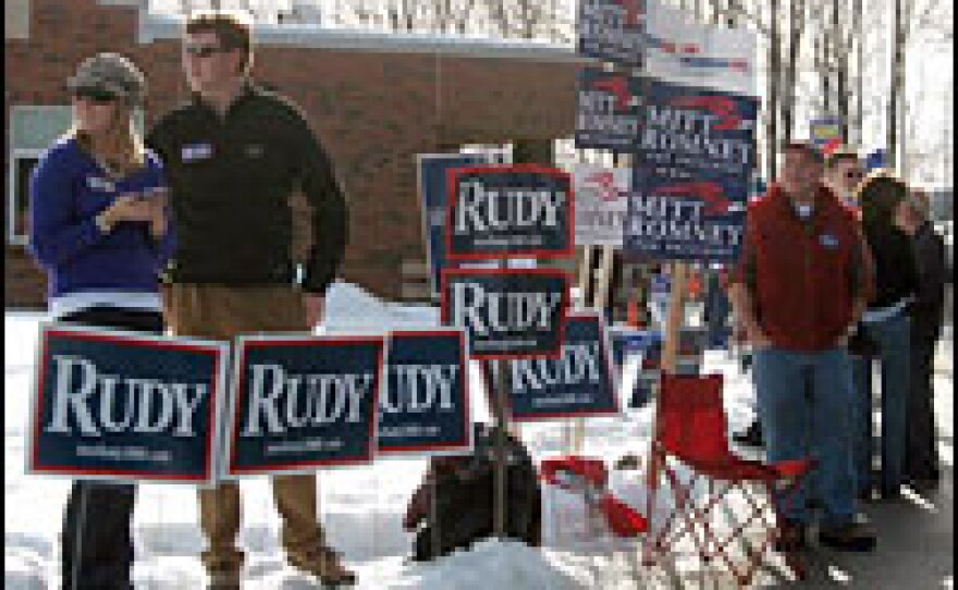 Supporters tout their candidates outside the polling site at Milford Middle School in Milford, N.H.