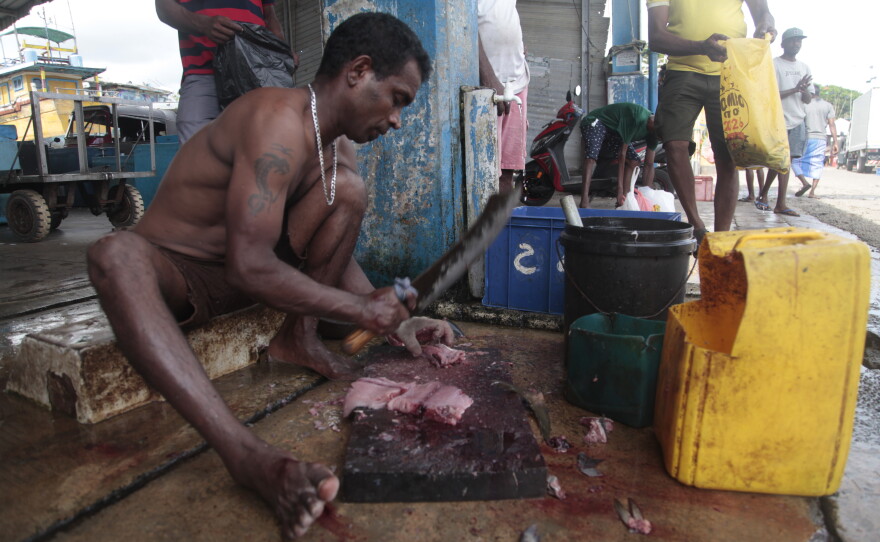 Dhanushka, who only goes by one name, chops up fish for tips at the Galle Fishing Harbor in southern Sri Lanka. Dhanushka says customers are giving him less — and there's just less customers — because of rising prices caused by the Mideast war.   Sri Lanka is thousands of miles from the Middle East, but the island of some 22 million people is deeply vulnerable to the impacts of the war that Israel and the U.S. launched on Iran on Feb. 28, because it imports two-thirds of its energy and nearly all its fertilizer — and much of those come through the Strait of Hormuz, which is blocked by the U.S. and Iran. It's the latest blow to Sri Lankans who have been reeling from years of back-to-back crises.