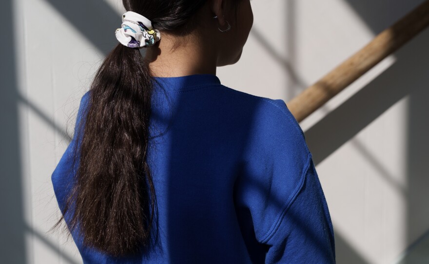 Ellah, the daughter of the principal and a student at the school, stands for a portrait in St. Paul, Minn., on March 18. She did not take the virtual learning option, and was excited when many of her classmates returned to the building.